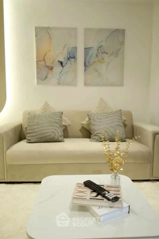 Elegant living room with modern art, plush sofa, and stylish decor