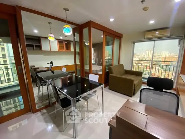 Modern condo interior with open layout, glass dining table, and city view balcony.
