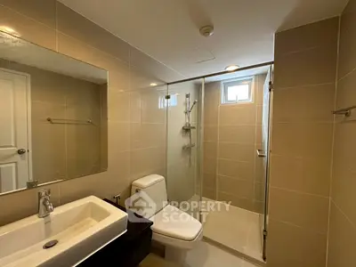 Modern bathroom with glass shower and sleek fixtures in a contemporary home.