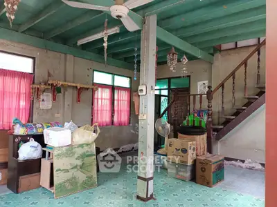 Charming rustic living room with wooden staircase and vintage decor, ideal for renovation enthusiasts.