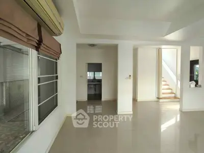 Spacious modern living room with large windows and sleek tile flooring