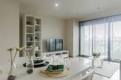 Modern living room with large windows and stylish decor in a high-rise apartment.