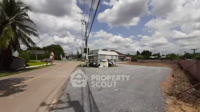 Spacious roadside plot with potential for development under a clear blue sky.
