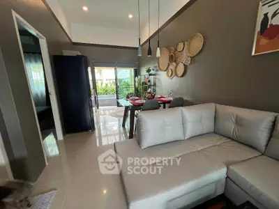 Modern living room with stylish decor and open dining area, featuring elegant lighting and garden view.