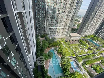 Stunning aerial view of modern high-rise buildings with lush gardens and a sparkling pool, perfect for urban living.
