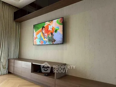 Modern living room with wall-mounted TV and sleek wooden cabinetry.