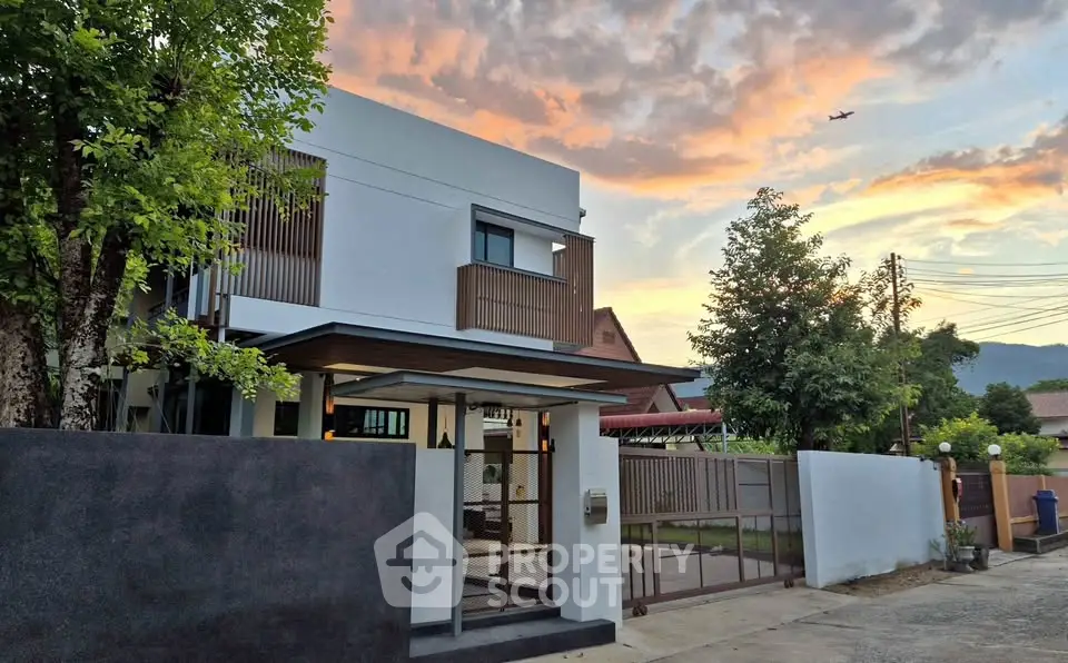 Modern two-story house with sunset view and lush greenery