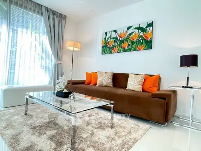 Stylish living room with modern decor, plush brown sofa, vibrant cushions, and elegant glass coffee table.