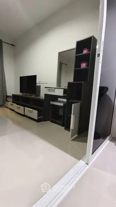 Modern living room with sleek TV stand and shelving unit, featuring minimalist design and neutral tones.