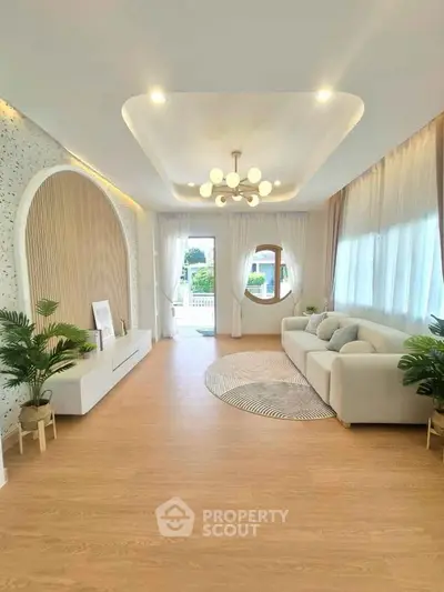 Spacious modern living room with elegant decor and large windows offering natural light.