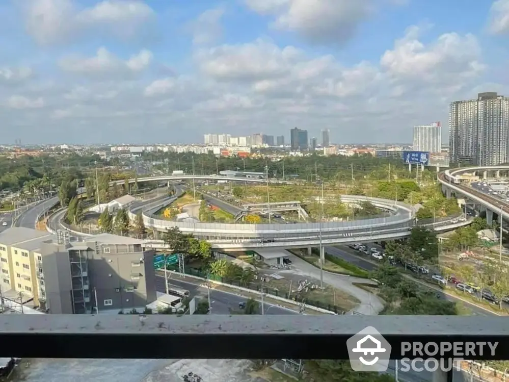 Stunning urban view from high-rise balcony overlooking cityscape and highway.