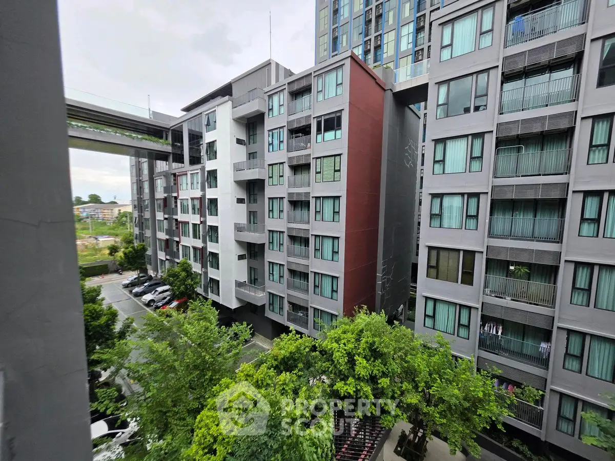 Modern apartment complex with lush greenery and urban view