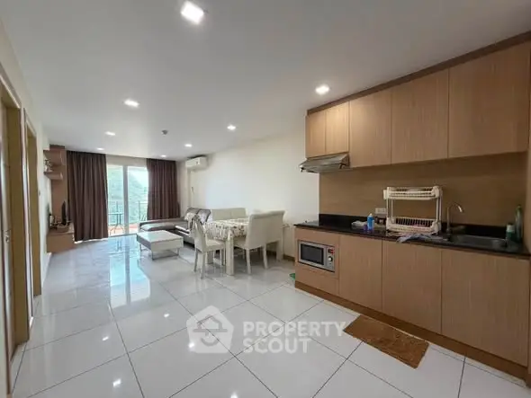Spacious modern living room with open kitchen and balcony view