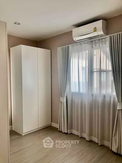 Cozy bedroom with air conditioning and elegant curtains in modern apartment