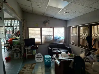 Cozy living room with large windows and comfortable seating in a well-lit home.