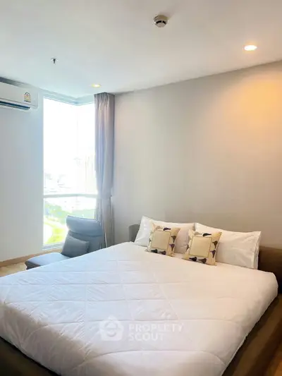 Modern bedroom with large window and cozy bed in a high-rise apartment.