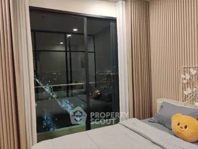 Cozy bedroom with city view and balcony access, featuring modern decor and plush bedding.