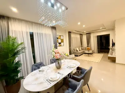 Luxurious open-plan living and dining area with elegant chandelier and modern decor.