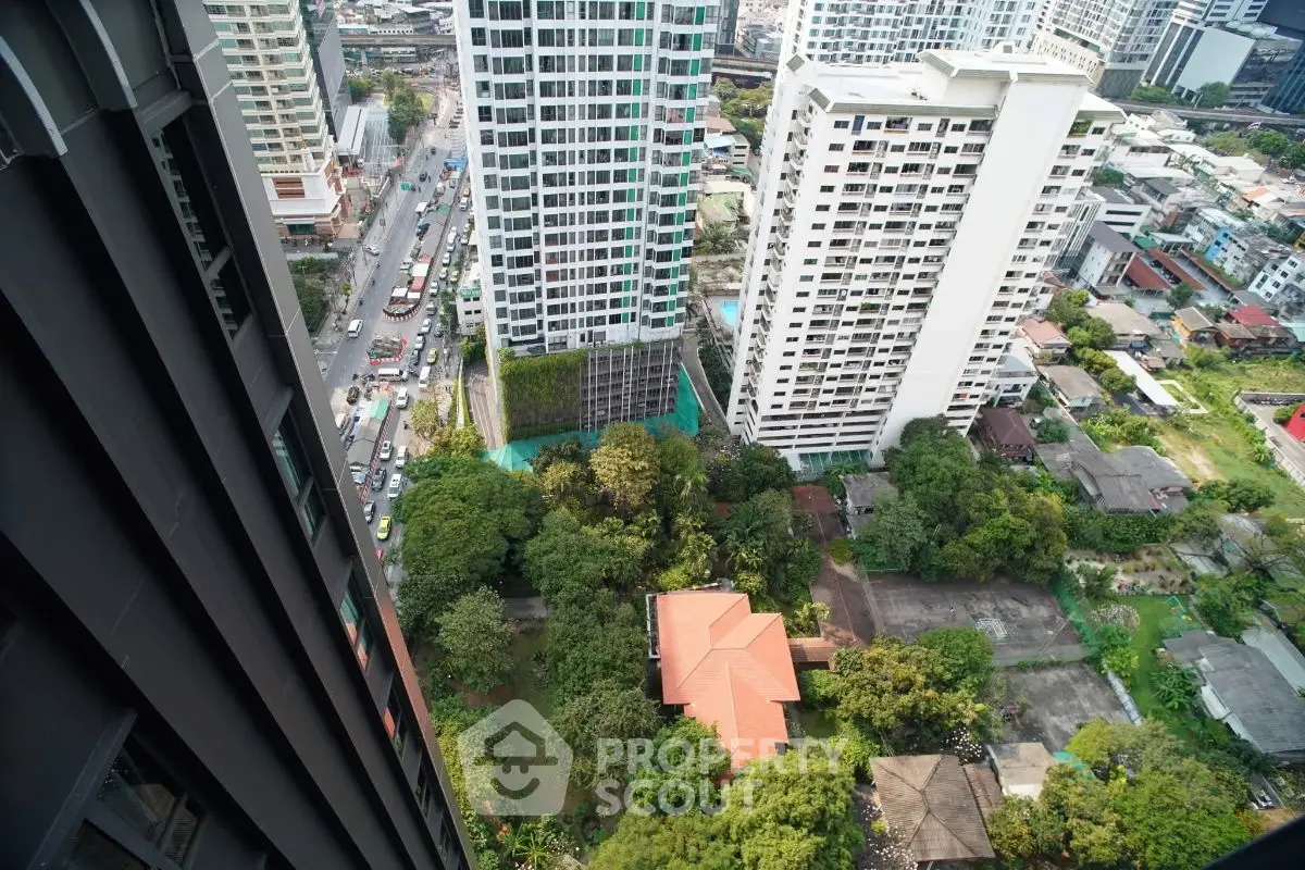 Stunning high-rise city view from a modern apartment balcony, showcasing urban landscape and greenery.