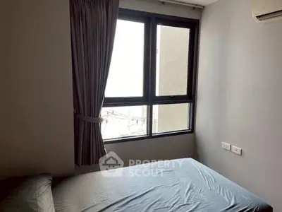 Cozy bedroom with natural light and modern window design.