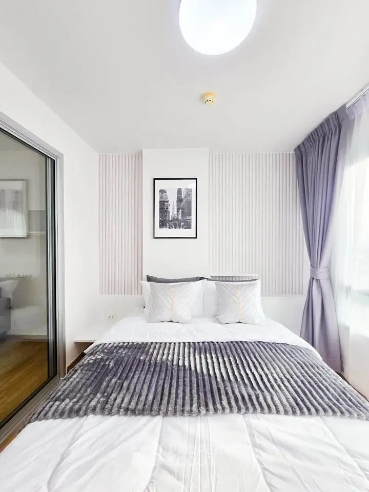 Cozy modern bedroom with stylish decor and ample natural light
