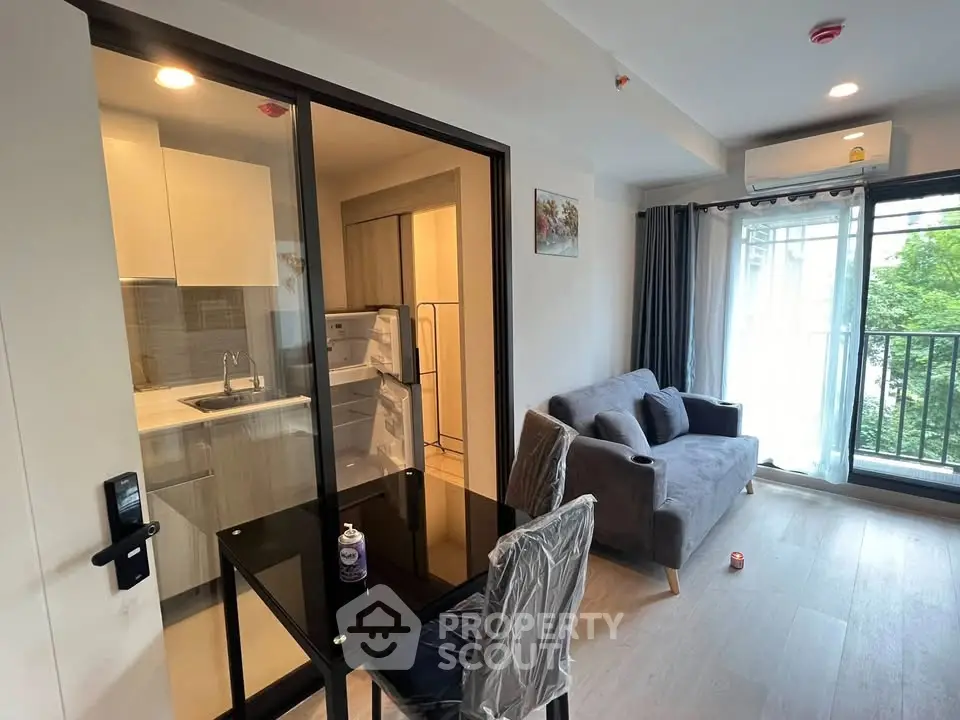 Modern living room with open kitchen and balcony view in a stylish apartment.