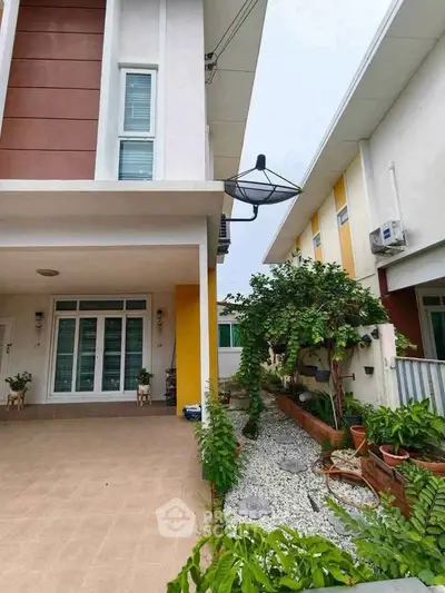 Modern townhouse exterior with landscaped garden and spacious driveway.