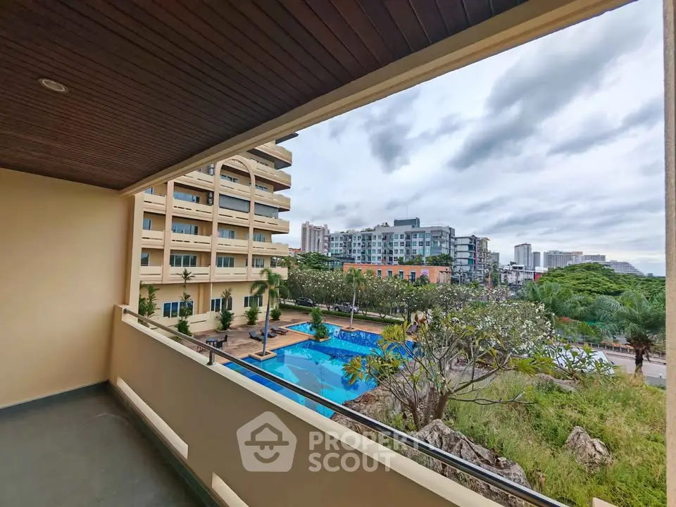 Spacious balcony with stunning pool view in modern apartment complex