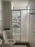 Modern bathroom with glass shower and colorful curtain