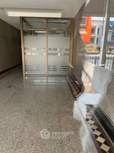 Spacious commercial entrance with glass doors and polished flooring