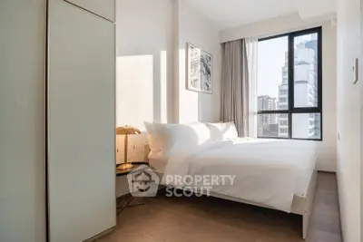 Bright and modern bedroom with large window and city view, featuring minimalist decor and cozy ambiance.