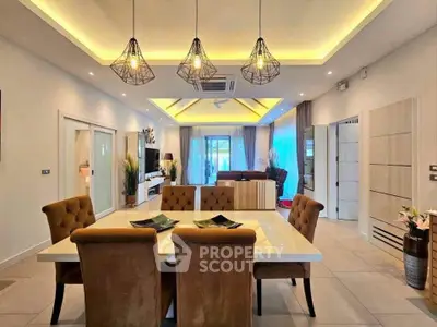 Luxurious open-plan living and dining area with modern lighting and elegant decor.