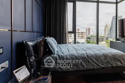 Luxurious bedroom with stunning city view and modern decor in high-rise apartment.