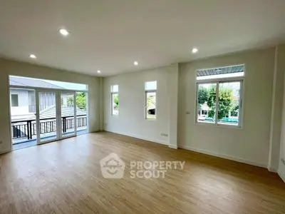 Spacious living room with large windows and wooden flooring in modern home