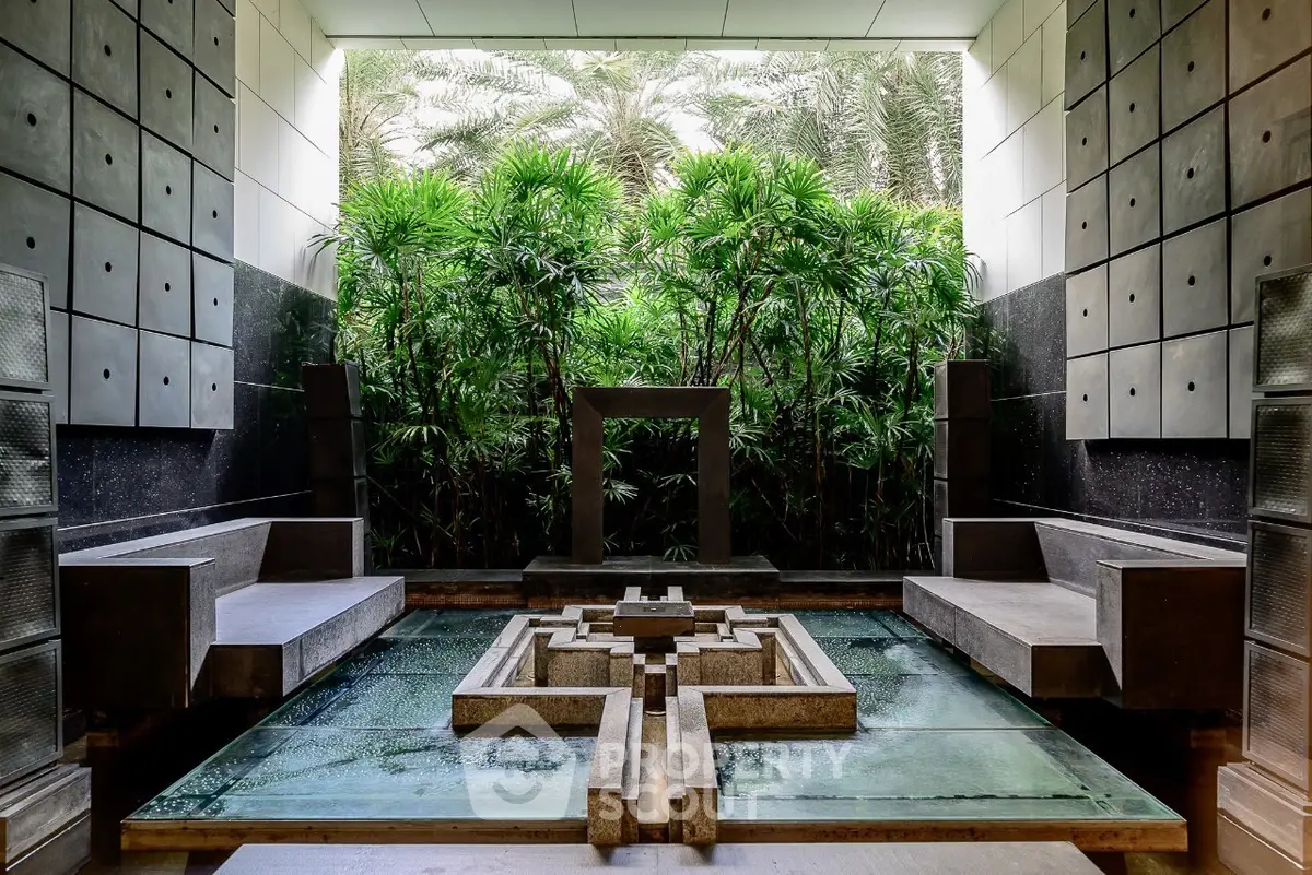 Luxurious modern garden with water feature and lush greenery in a sophisticated setting.