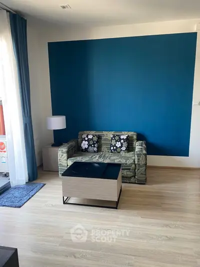 Stylish living room with modern decor and blue accent wall, perfect for relaxation.