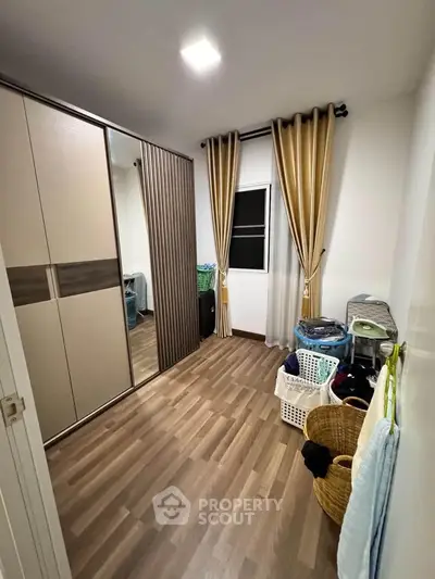 Spacious storage room with modern wardrobe and wooden flooring