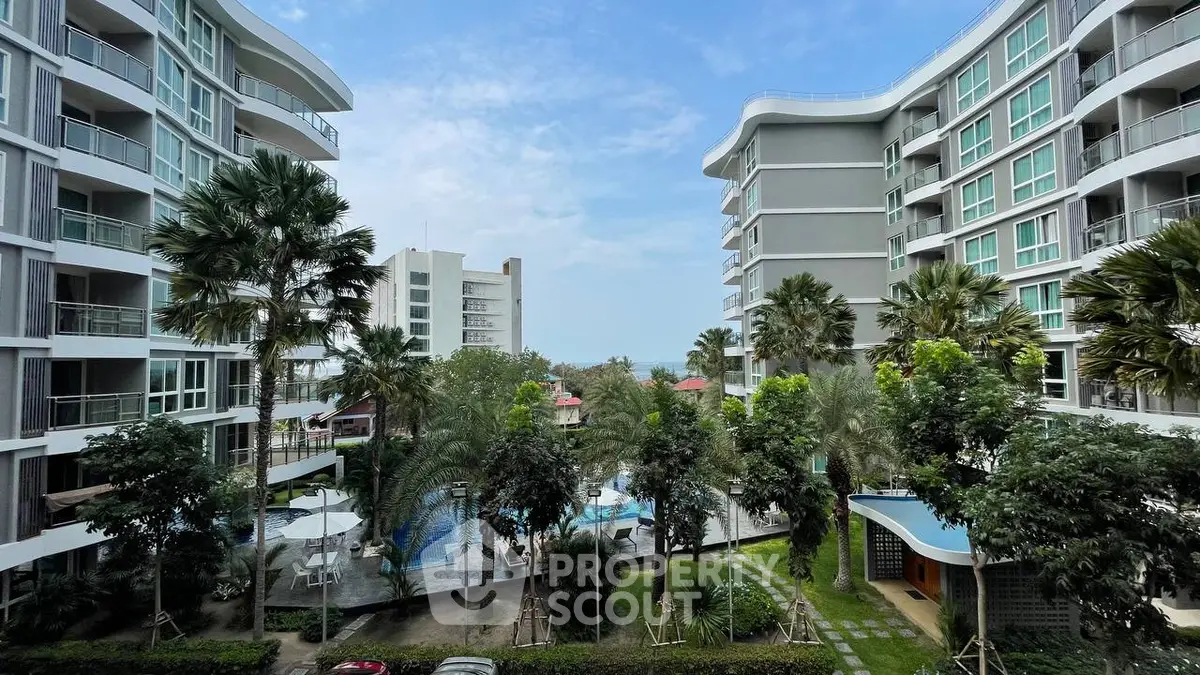 Stunning view of modern apartment complex with lush gardens and pool area.