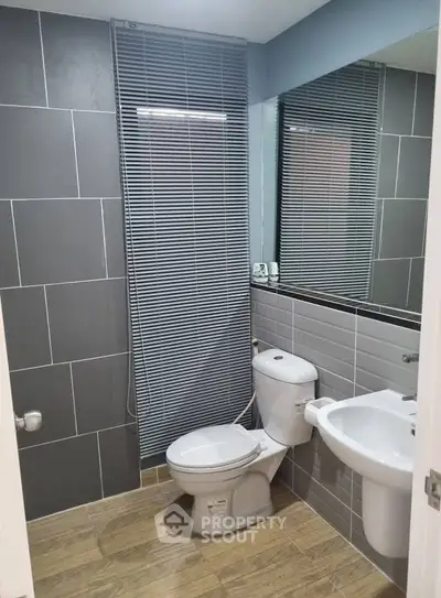 Modern bathroom with sleek gray tiles and contemporary fixtures.