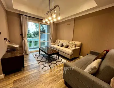 Elegant living room with modern lighting and cozy sofas, featuring a view of the garden through large windows.