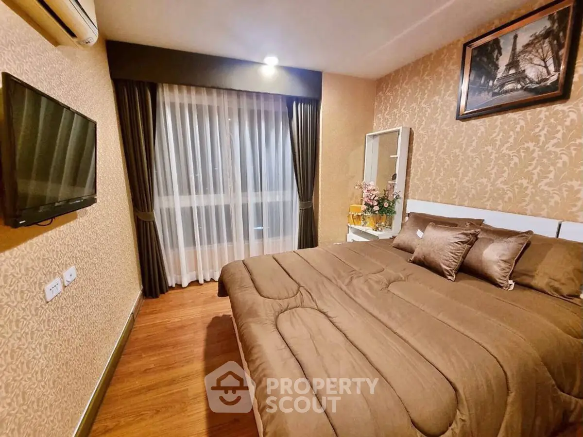 Cozy bedroom with elegant decor, featuring a plush bed, wall-mounted TV, and stylish curtains.