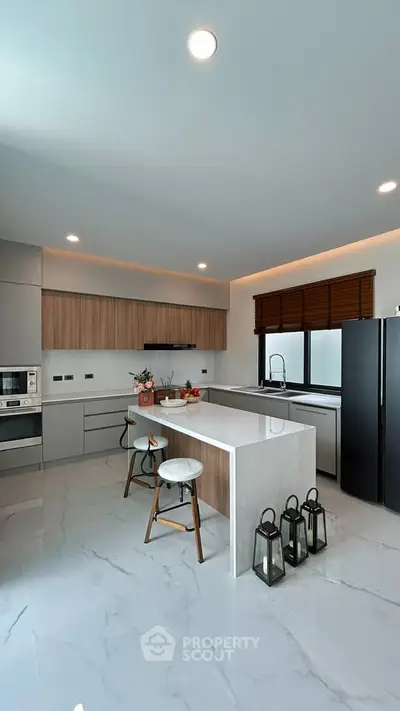 Modern kitchen with sleek design, featuring an island, high-end appliances, and elegant lighting.