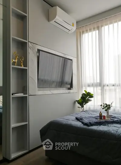 Modern bedroom with wall-mounted TV and large window