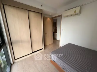 Modern bedroom with built-in wardrobe and air conditioning in a stylish apartment.