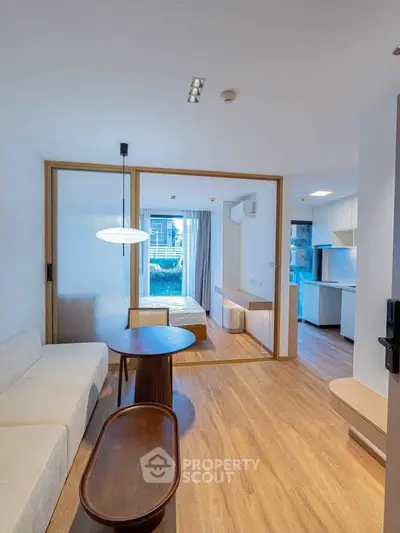 Modern open-plan living room with wooden flooring and stylish furniture in a contemporary apartment.