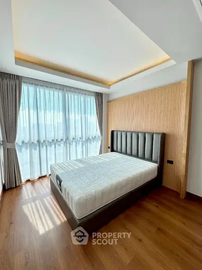 Spacious bedroom with modern design and large windows for natural light.