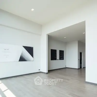 Spacious modern interior with high ceilings and minimalist design, perfect for versatile living spaces.