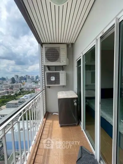 High-rise balcony with city view and air conditioning units, perfect for urban living.