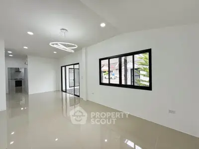 Spacious modern living room with large windows and sleek lighting in a contemporary home.