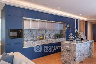 Luxurious modern kitchen with blue cabinetry and marble countertops in a stylish open layout.